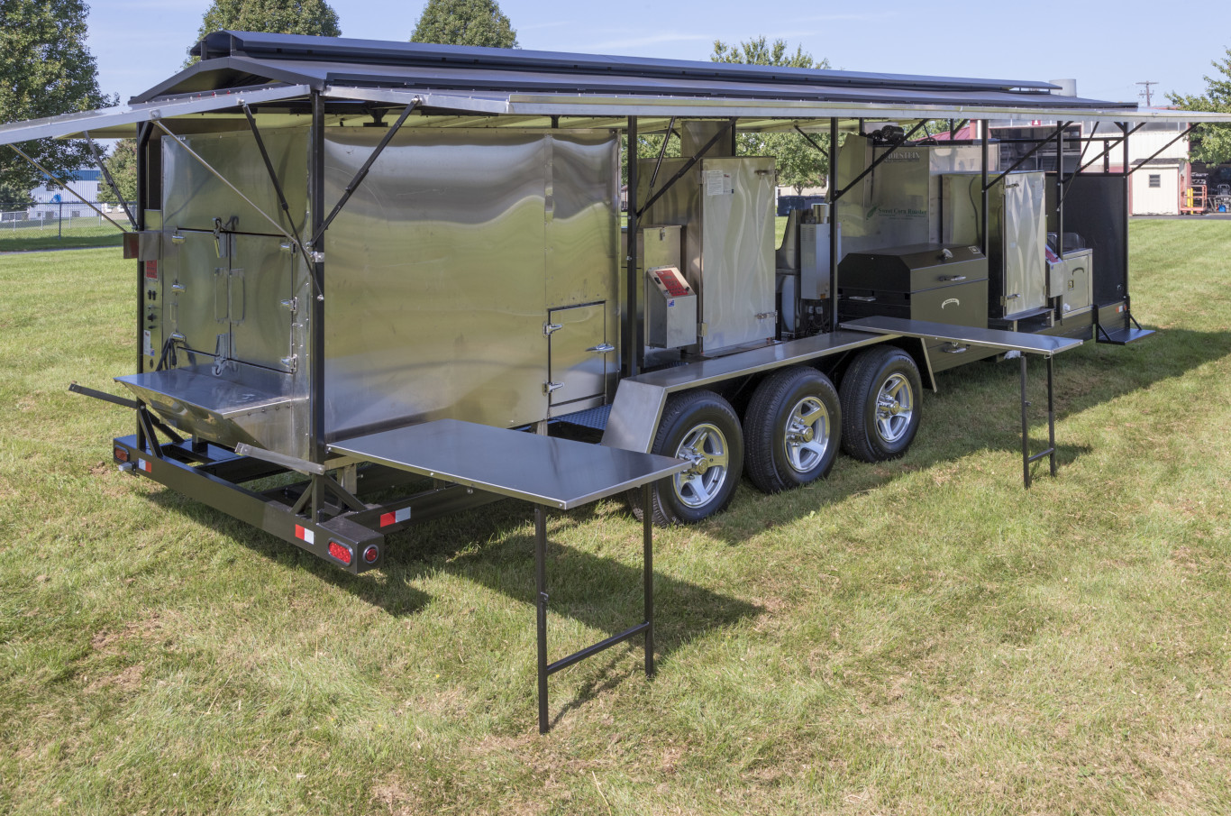 Custom Barbecue Trailer with roof raised and folding stainless steel tables deployed as an example of custom barbecue trailers